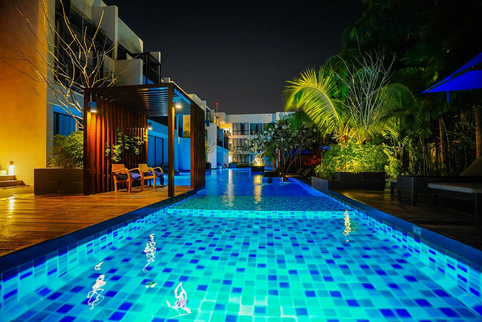 inmobiliaria de lujo vista nocturna de piscina iluminada en casa premium